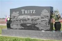 A black gravestone with the name tritz on it in a cemetery.