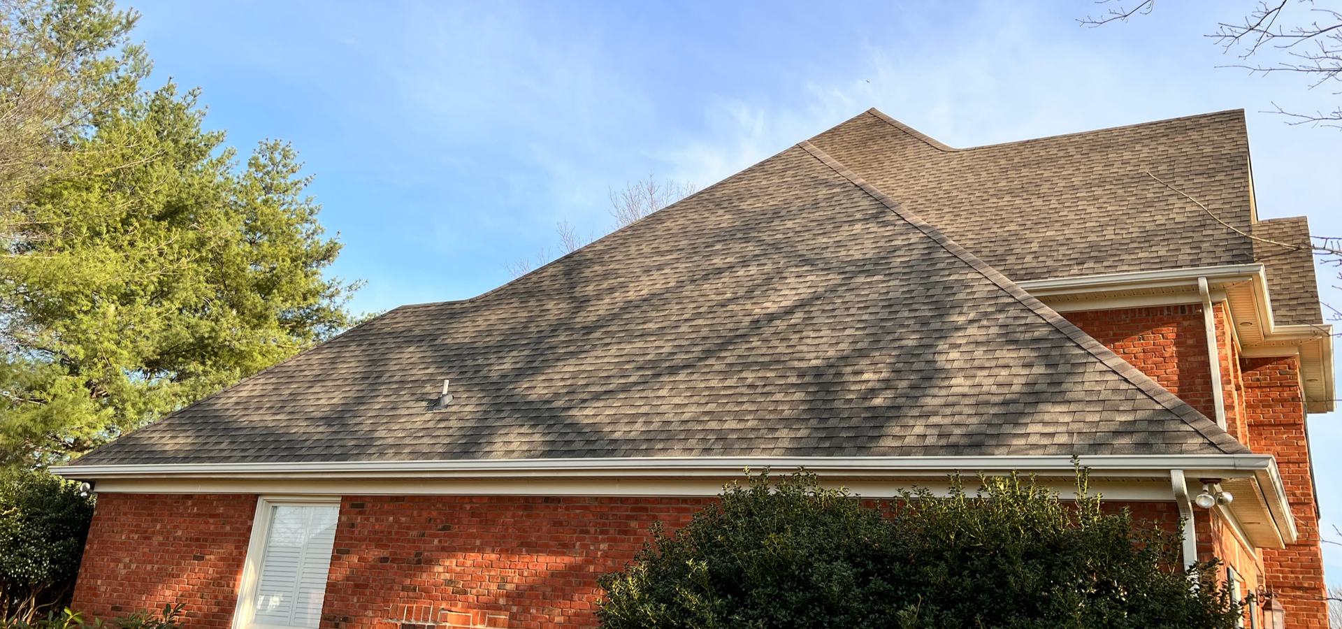 Roofs of two buildings, one gray and one brown, sit next to each other.