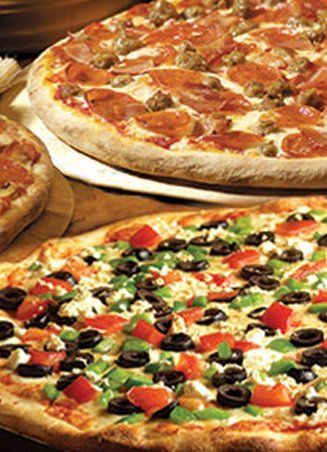 Three pizzas, close-up. One with meat, another with vegetables and olives, and a smaller one to the left.