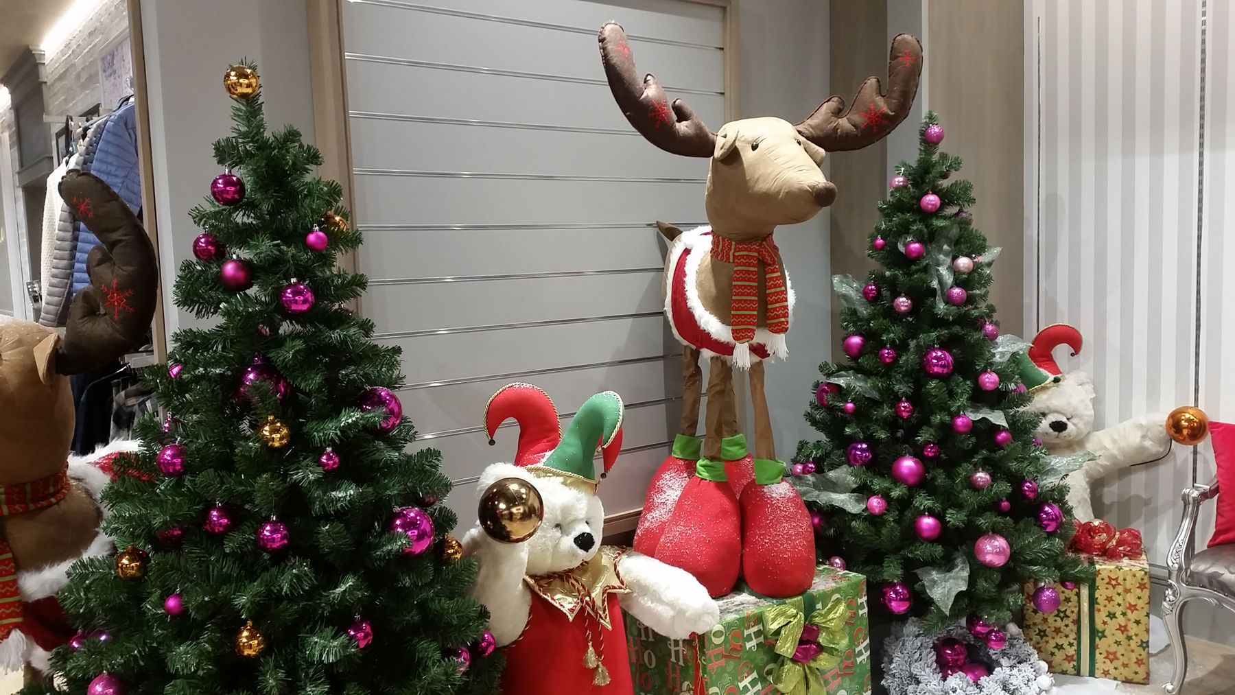 A christmas tree with a reindeer standing next to it.