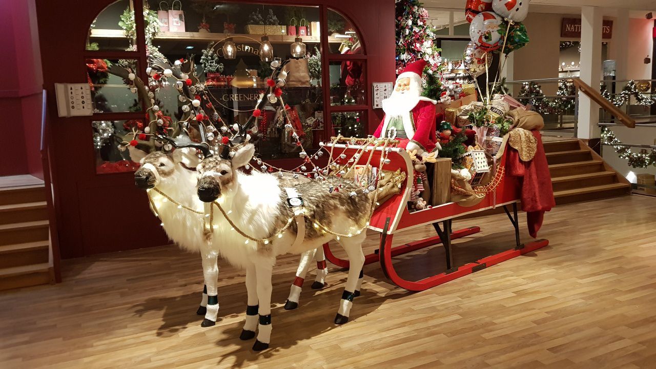 Santa claus is riding in a sleigh pulled by reindeer.