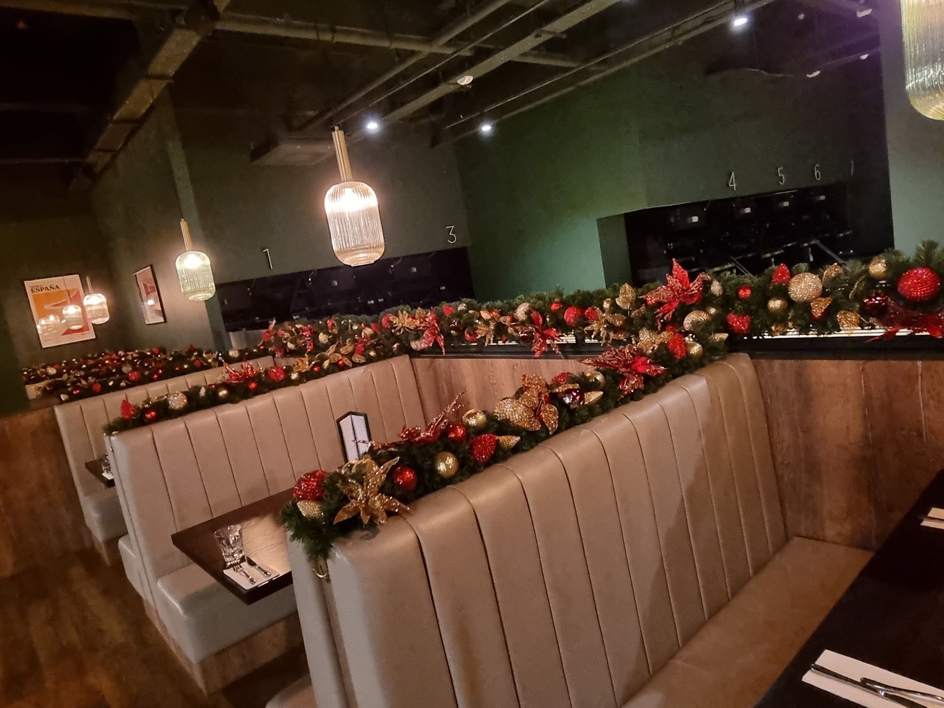A restaurant with christmas decorations on the benches and tables.