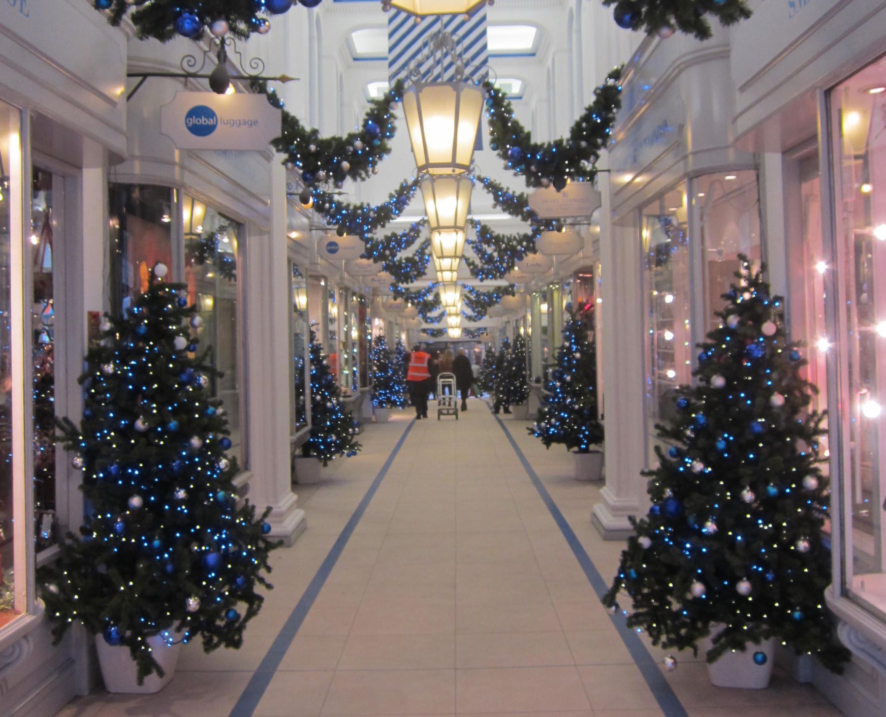 Christmas trees are lined up in a shopping mall.
