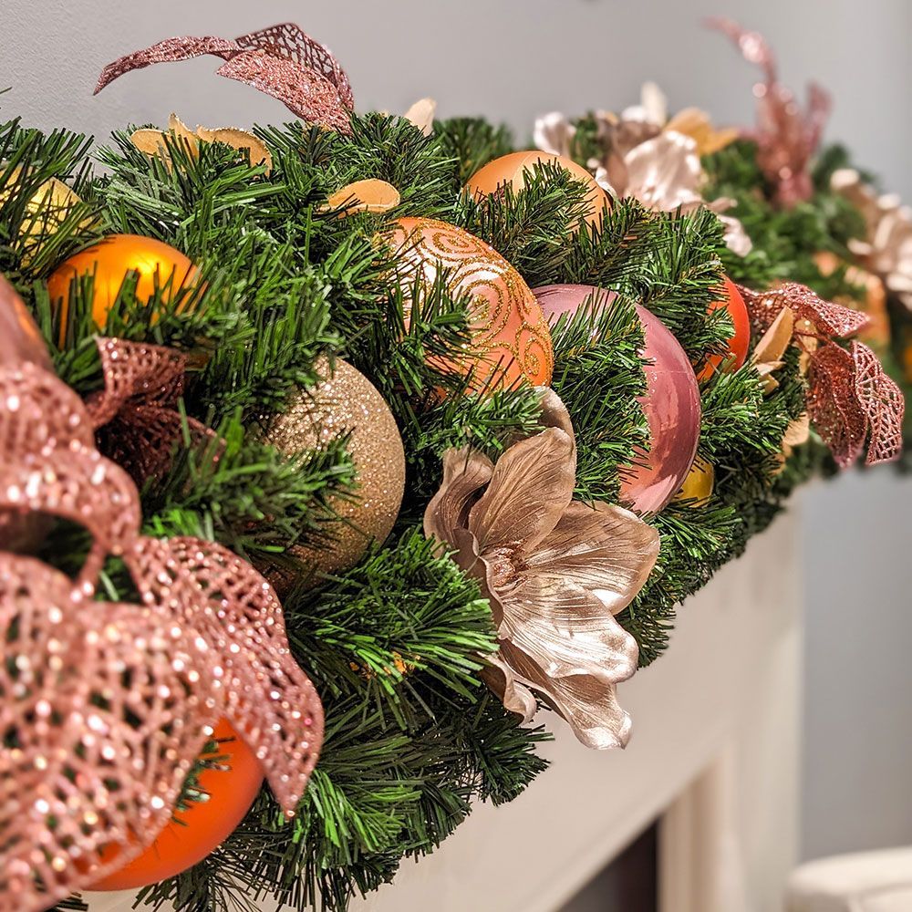 A christmas garland is sitting on top of a fireplace mantle.