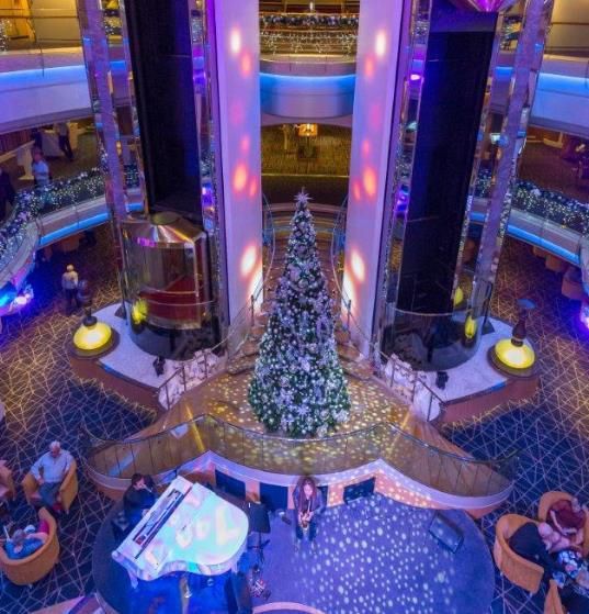 An aerial view of a hotel lobby with a christmas tree and a piano.