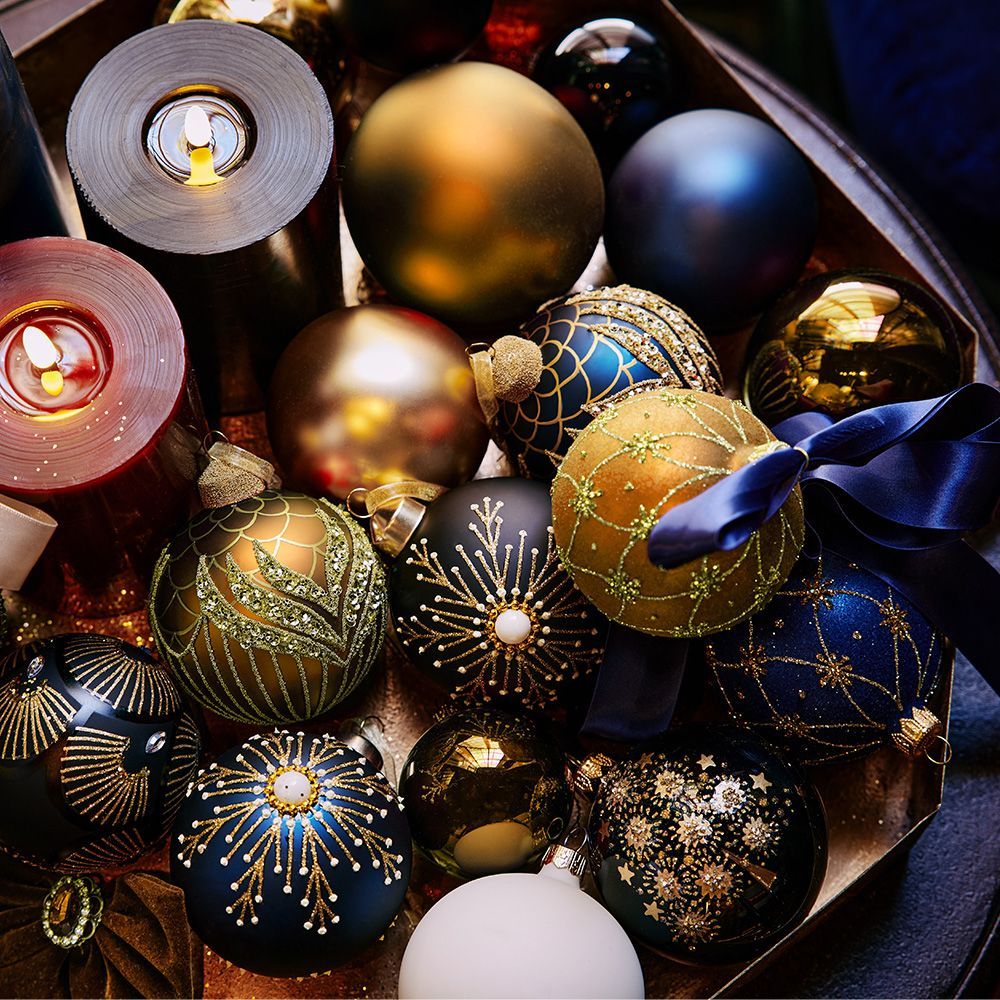 A bunch of christmas ornaments and candles on a table.