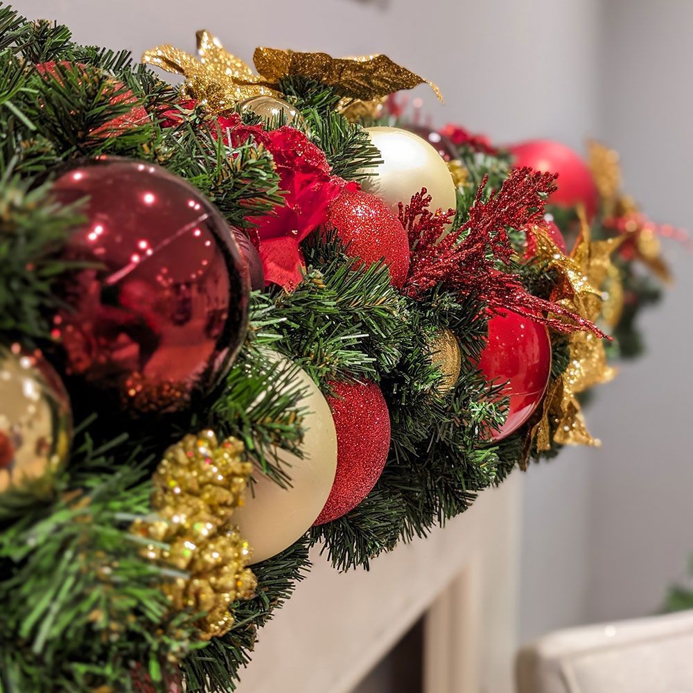 A close up of a christmas wreath on a mantle.