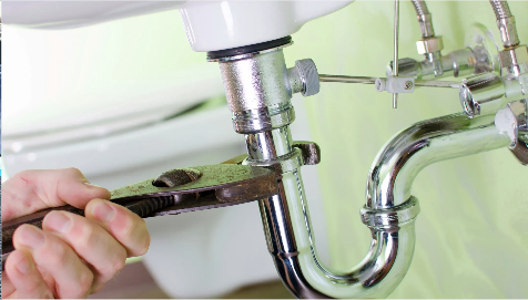 A person is fixing a sink with a wrench.