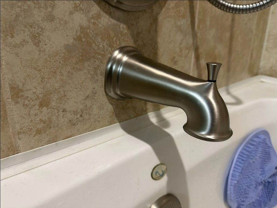 A bathtub with a faucet attached to the wall