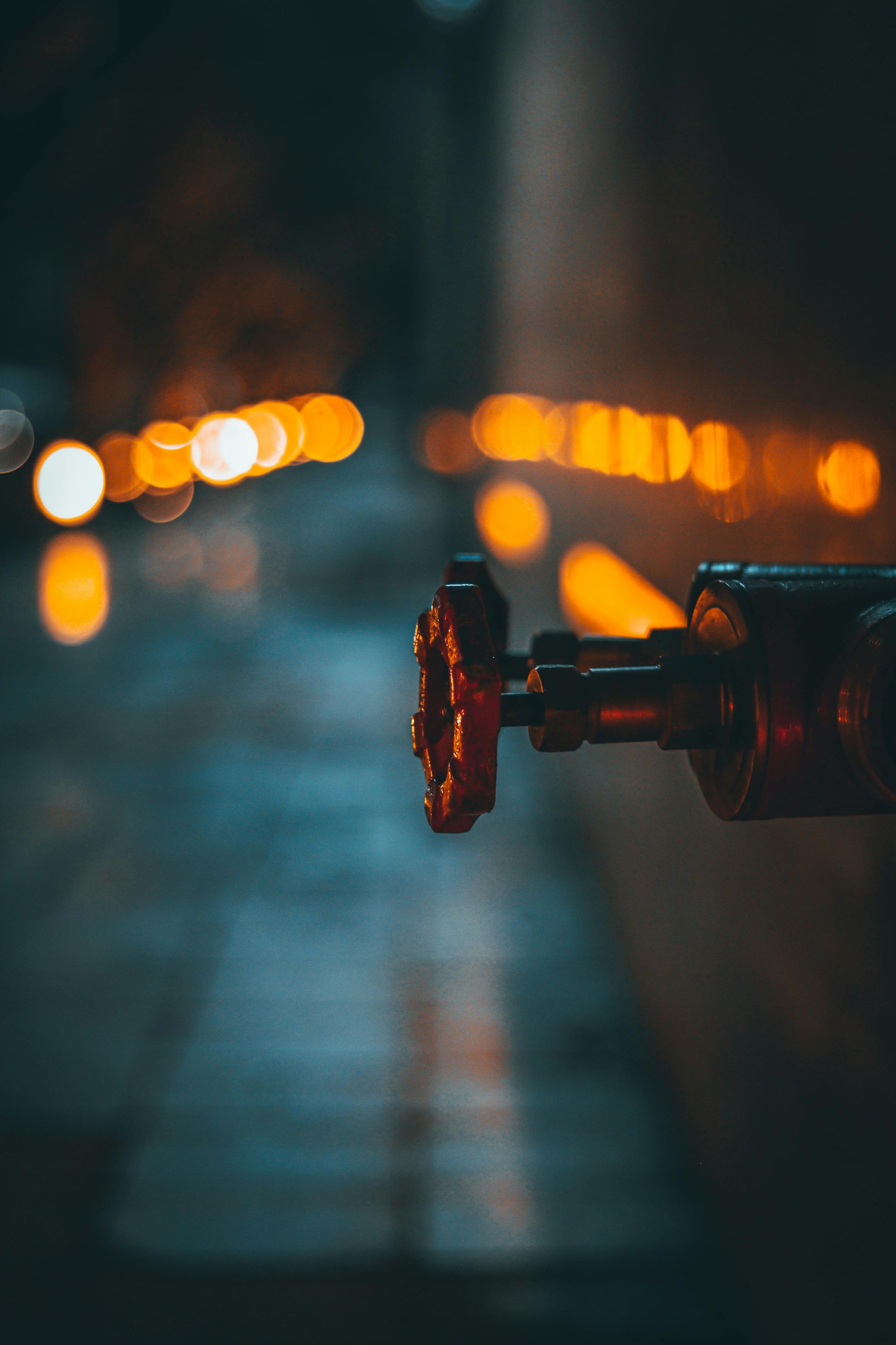 A close up of a fire hydrant on a street at night.