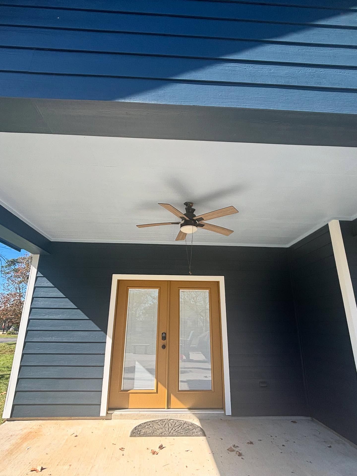 A living room with a fireplace, television, leather armchair, wooden coffee table, and an open dining area beyond.