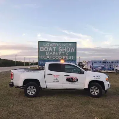 White pickup truck in front of a sign for the Lovers Key Boat Show Market & Seafood Fest.