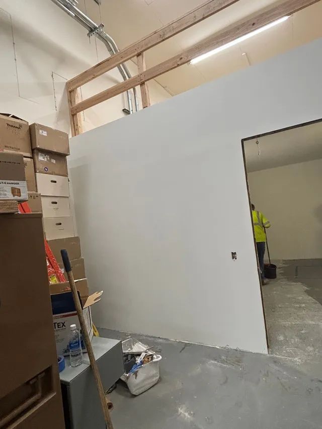 A room with a lot of boxes on the floor and a white wall.