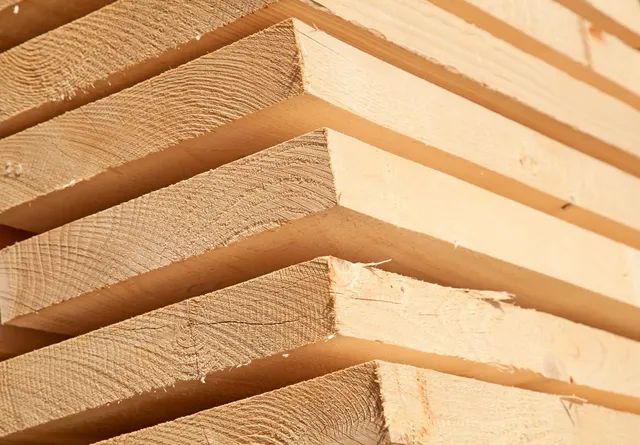 A close up of a pile of wooden boards stacked on top of each other.