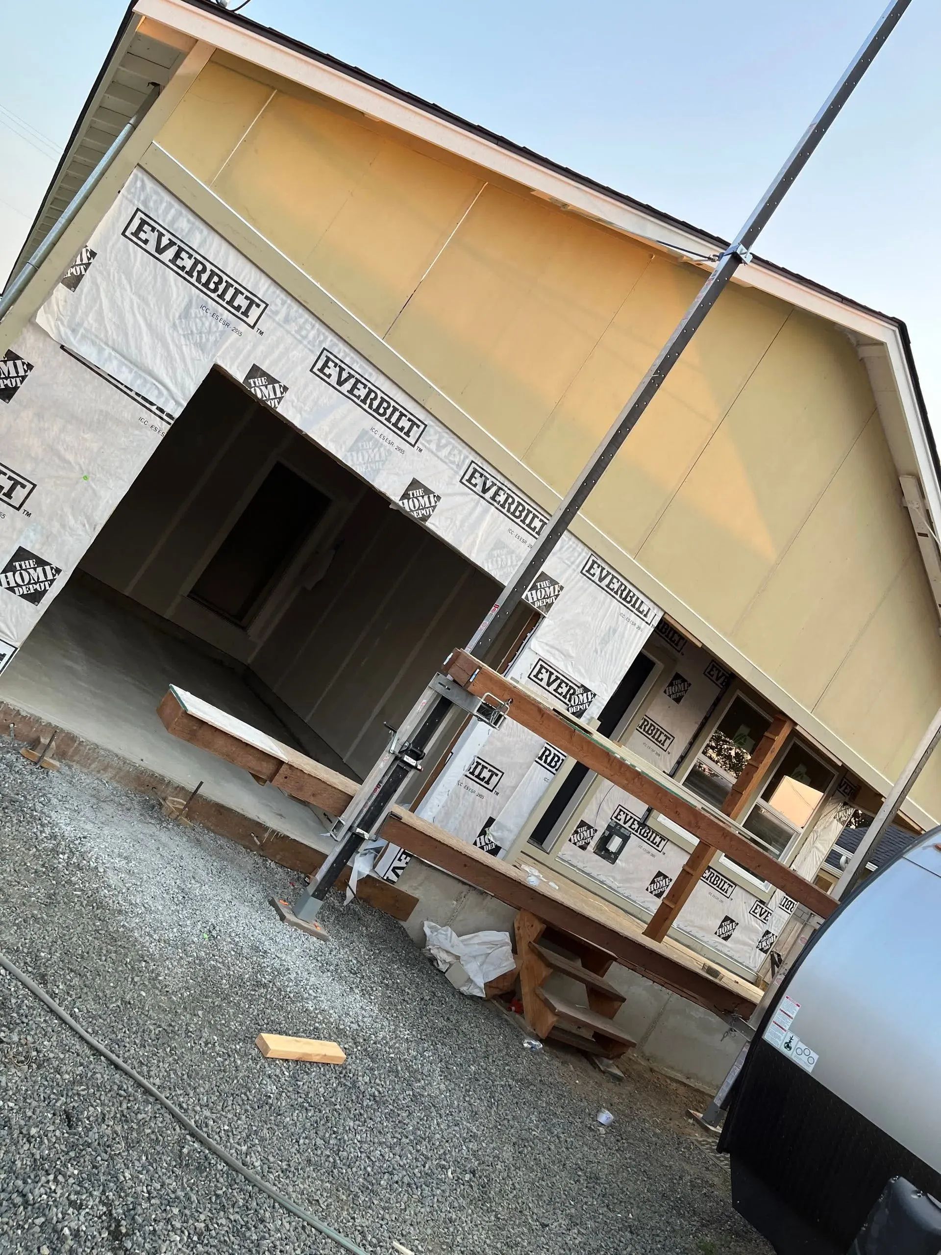 A house is being built with a van parked in front of it.
