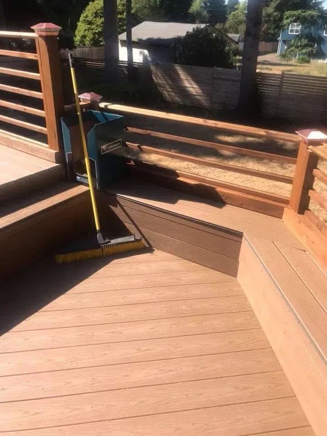 A broom is sitting on top of a wooden deck.