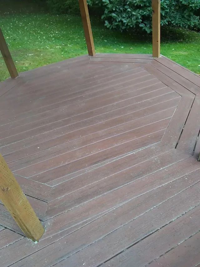 A wooden deck with a gazebo in the background.