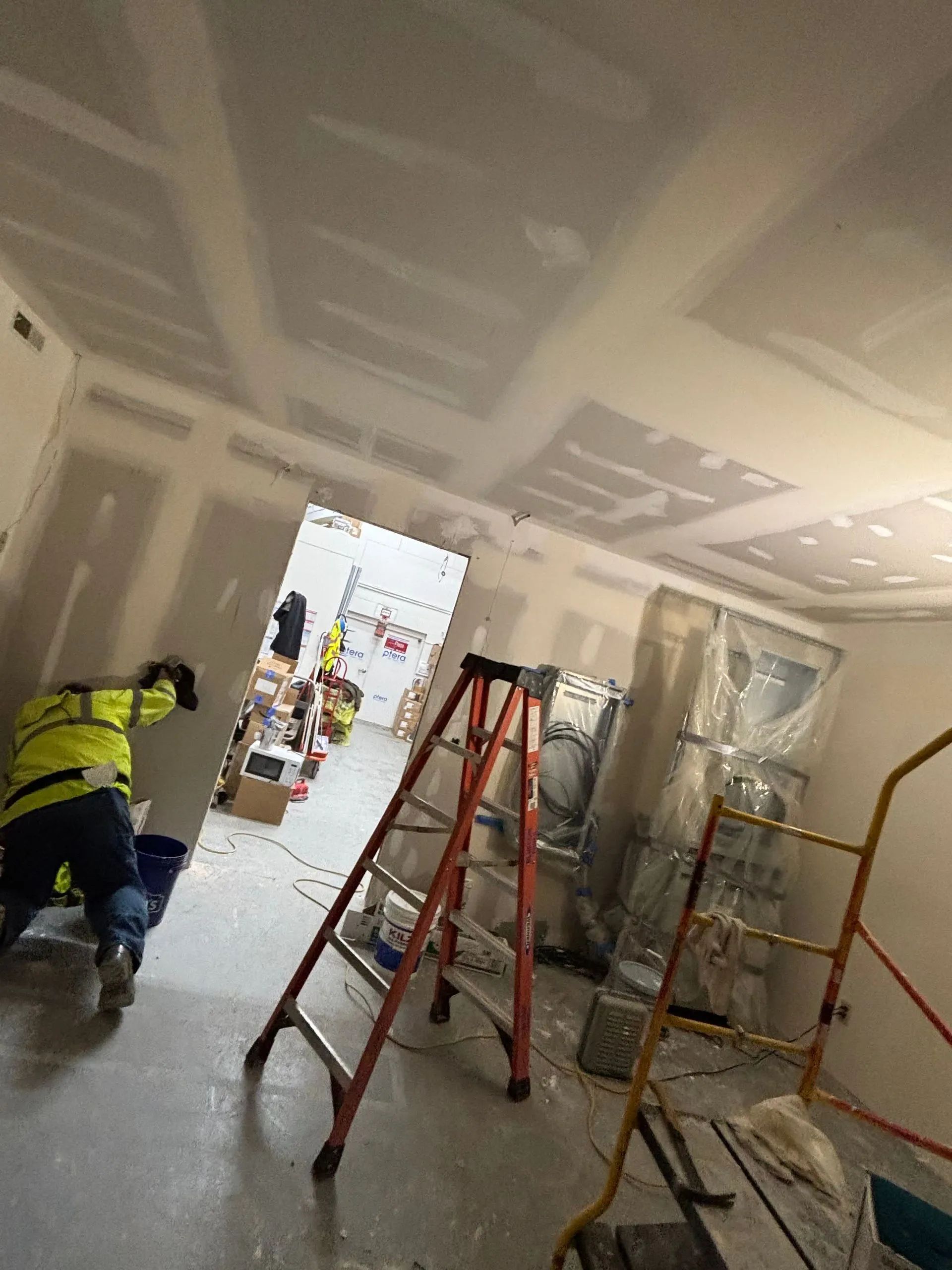 A man is standing in a room with a ladder in it.
