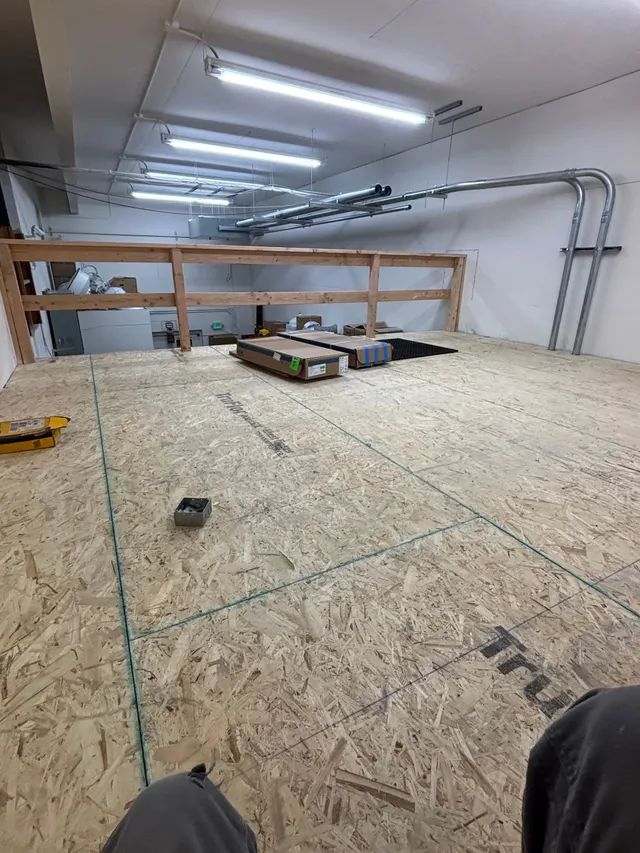 A person is standing on a wooden floor in a room.