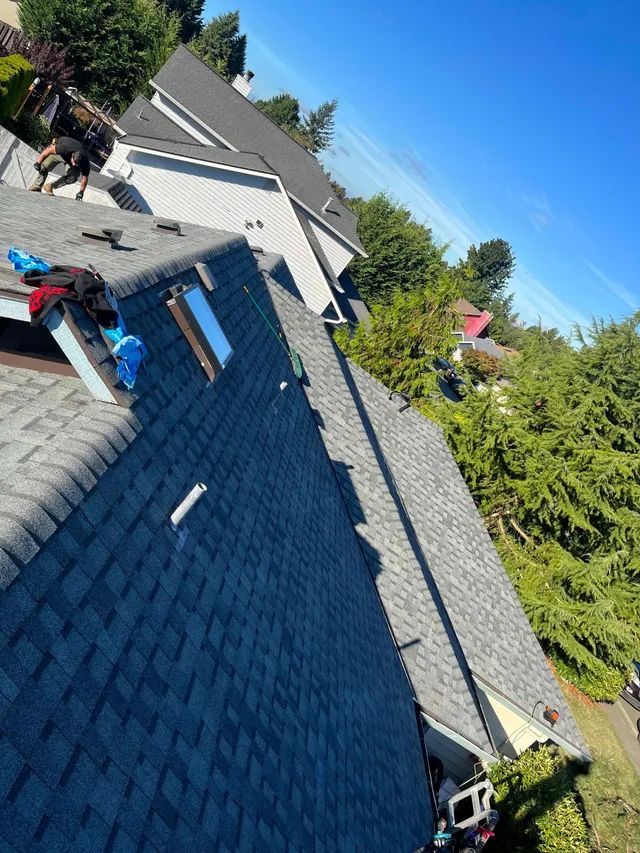 A man is standing on the roof of a house.