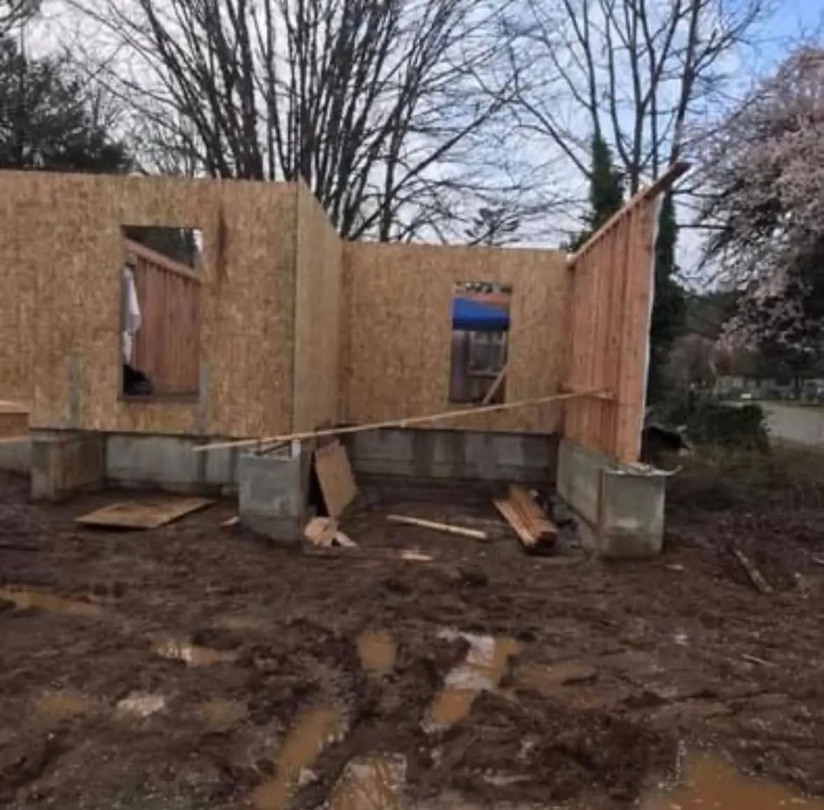 A house is being built in the middle of a muddy field