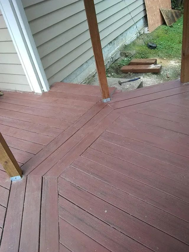A wooden deck is being built in front of a house.
