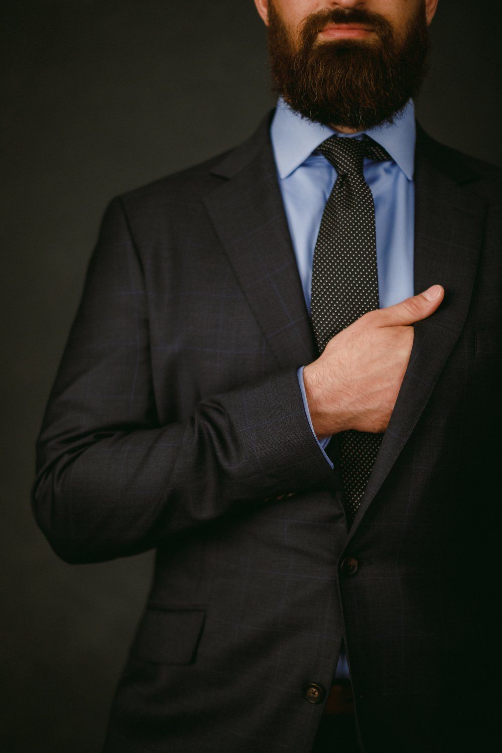 A man with a beard is wearing a suit and tie.