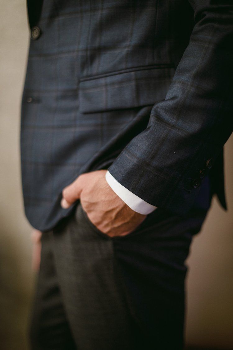 A man in a suit is standing with his hands in his pockets.