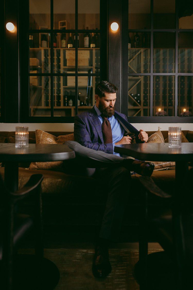 A man in a suit and tie is sitting at a table in a restaurant.