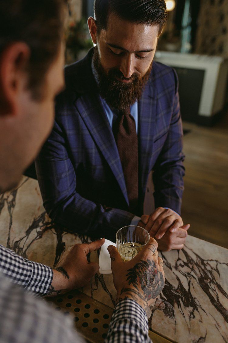 A man in a suit and tie is sitting at a table with another man.