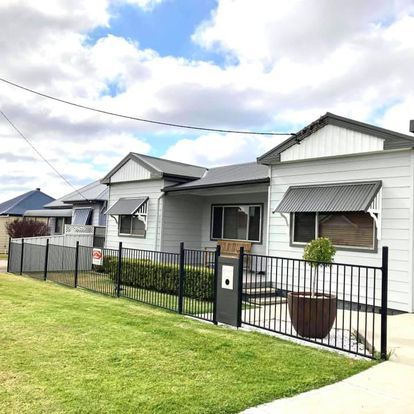 A row of white houses with a black fence — Heritage Window Awnings in the Hunter Valley, NSW