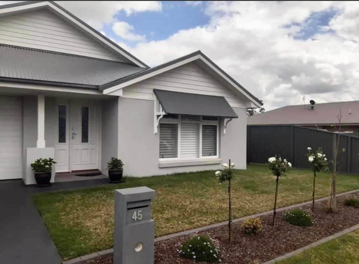 A white house with a mailbox in front of it — Heritage Window Awnings in the Hunter Valley, NSW