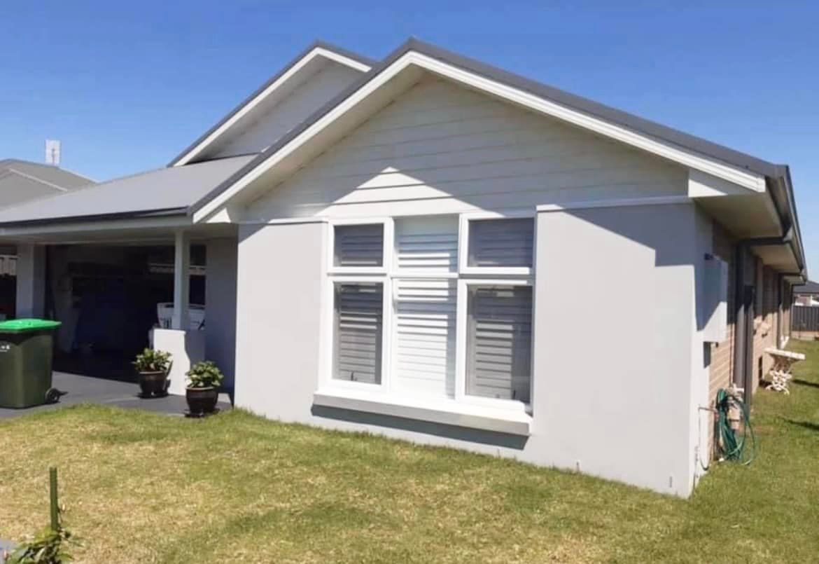 A white house with a green trash can in front of it — Heritage Window Awnings in the Hunter Valley, NSW