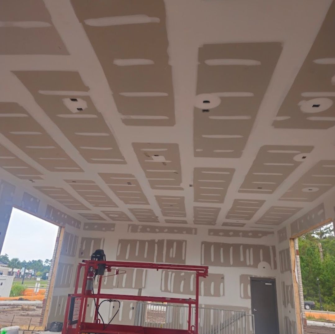 A blue house with a white porch overlooking a body of water