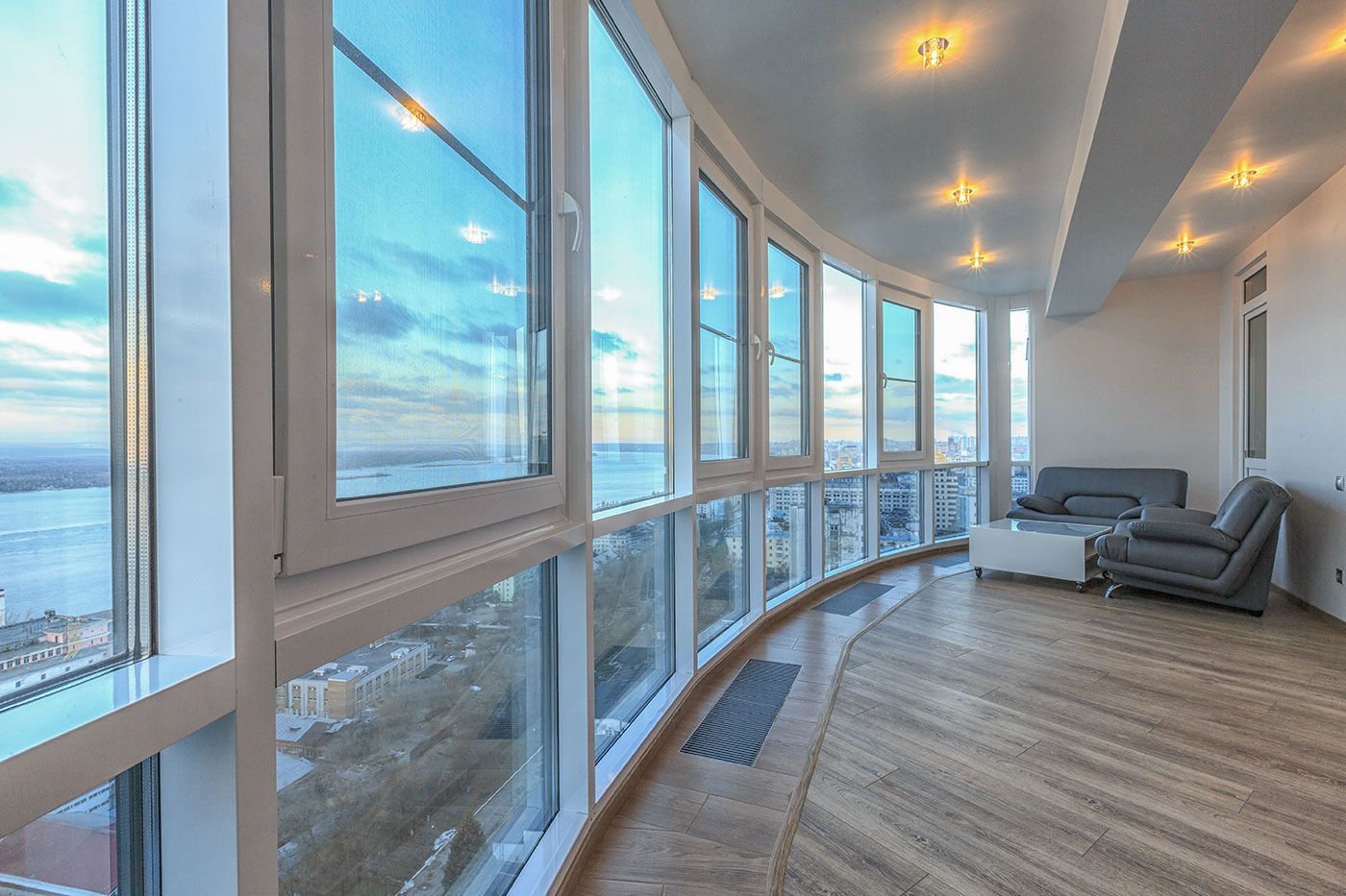 A living room with a lot of windows and a view of the ocean.