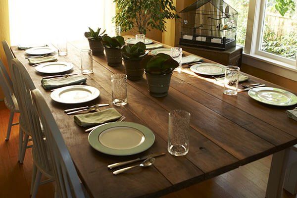 A long wooden table with plates and glasses on it