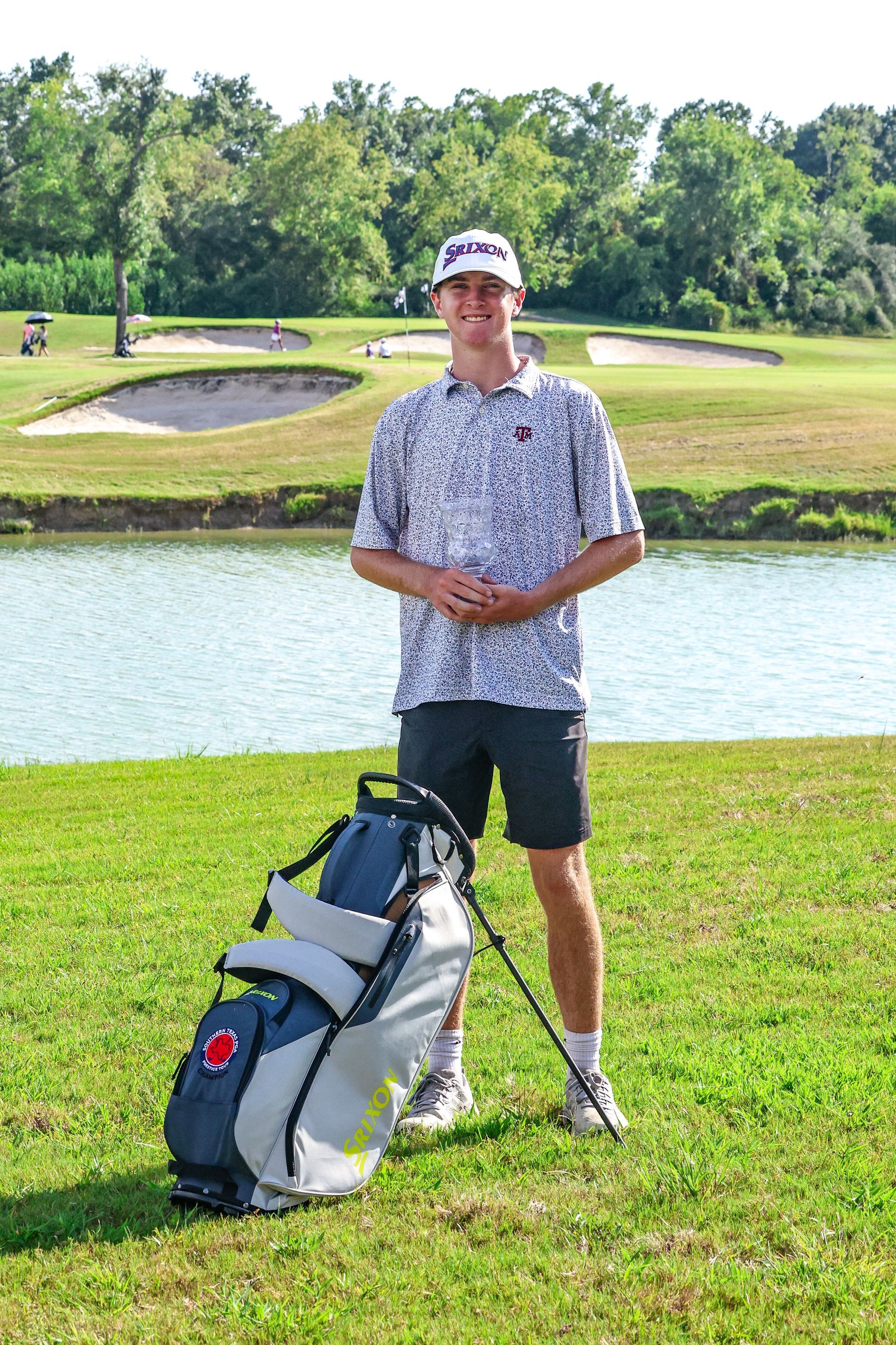 A woman is standing on a golf course with a golf bag.