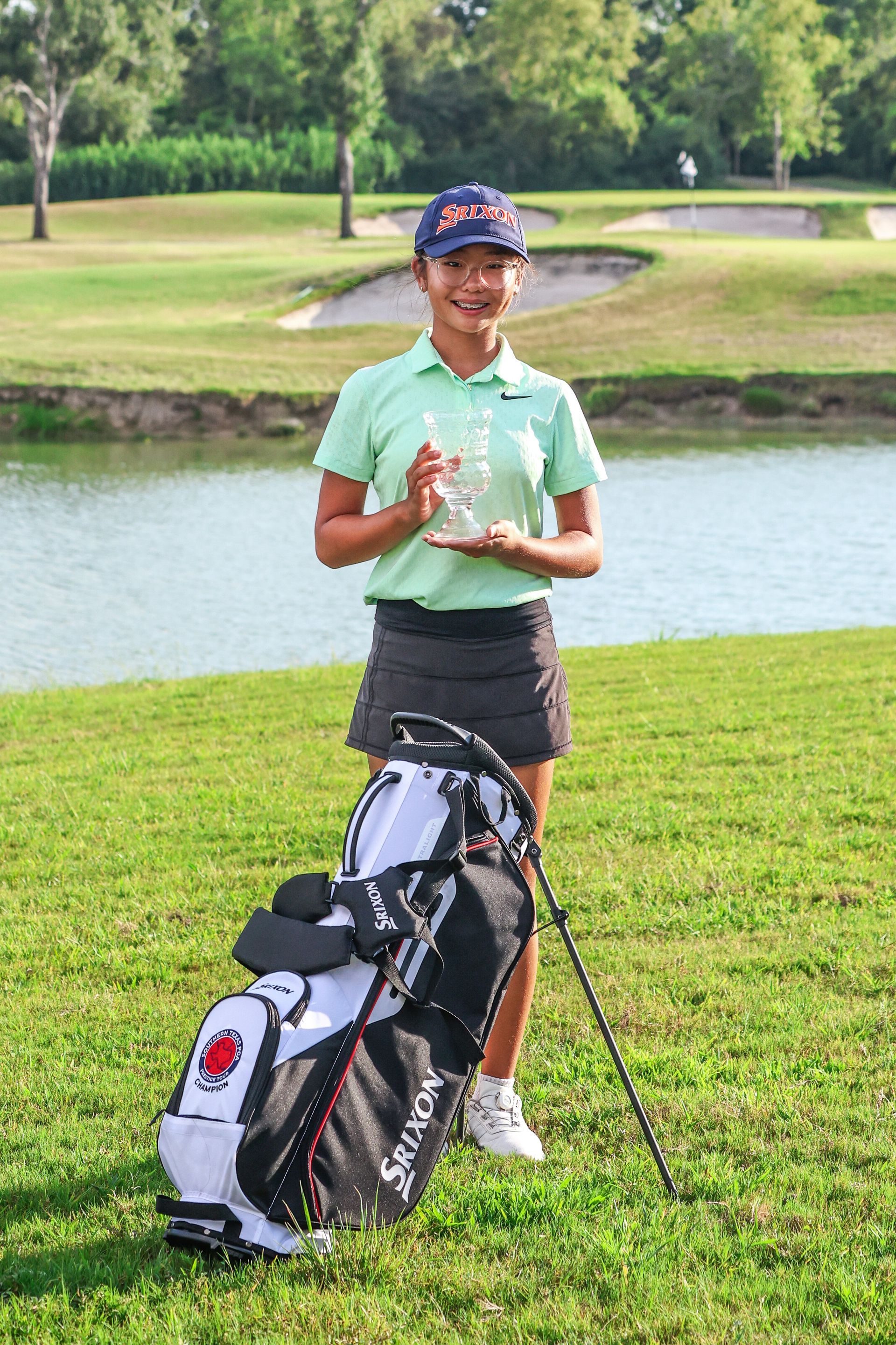 A man is standing next to a golf bag on a golf course.
