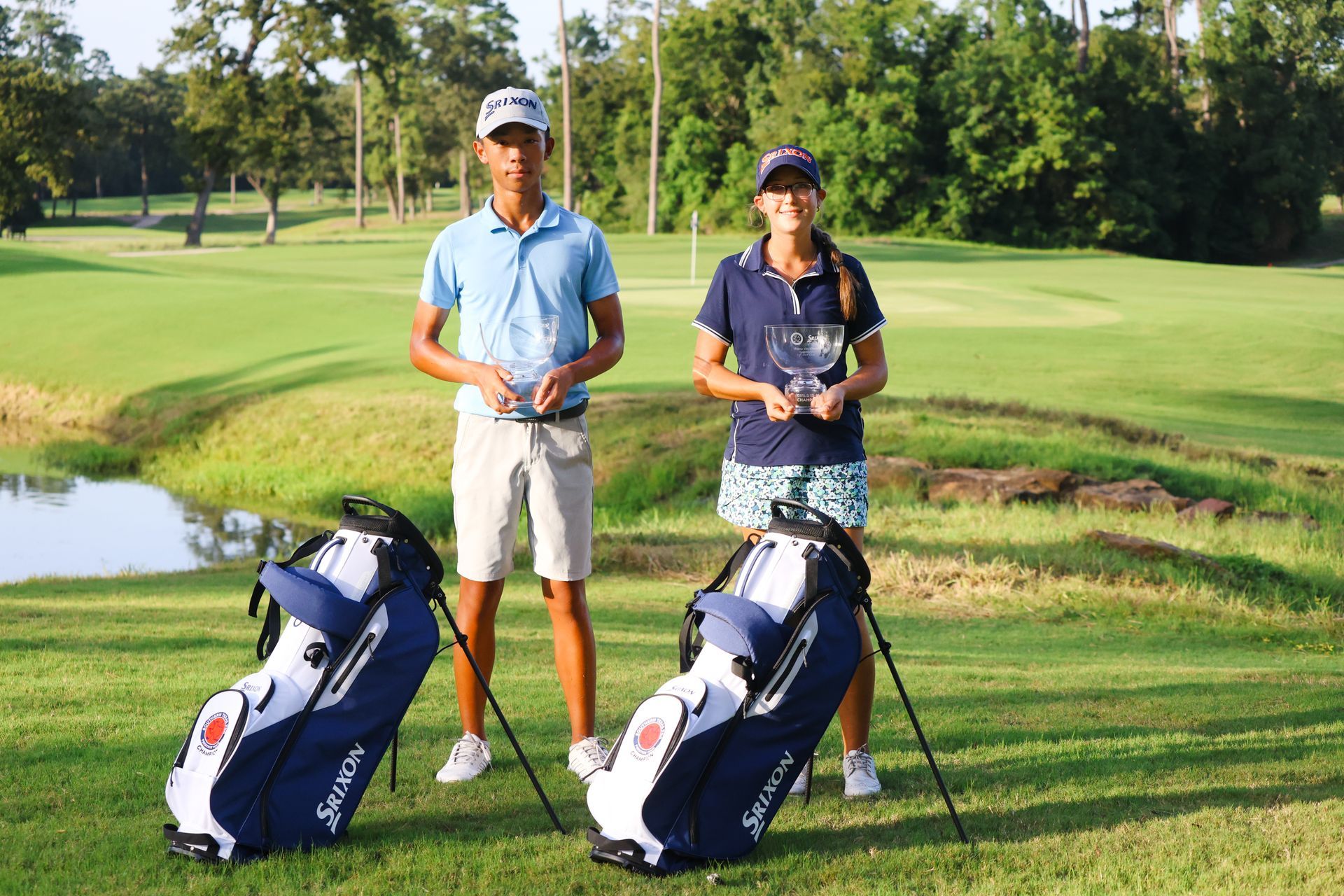 A man and a woman are standing next to golf bags on a golf course.
