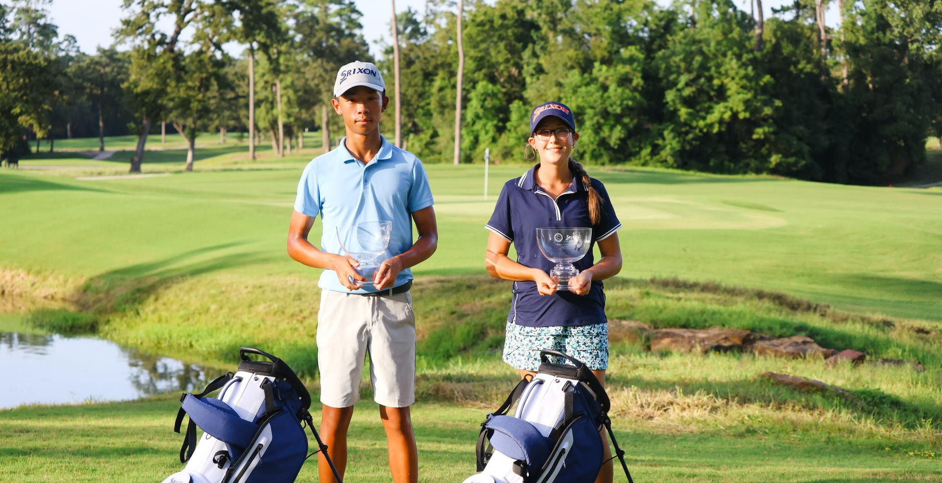 A man and a woman are standing next to golf bags on a golf course.
