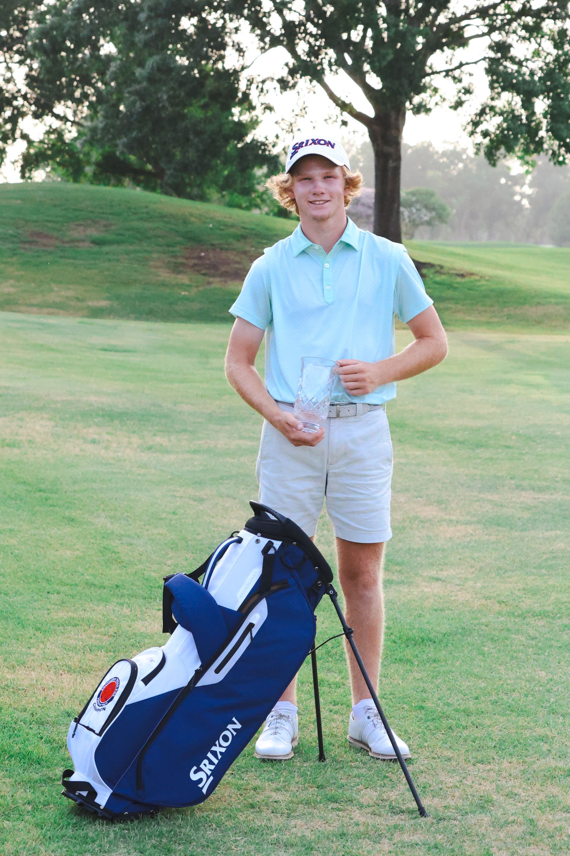 A man standing next to a golf bag that says srixon