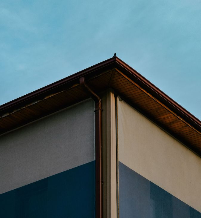 Corner of a modern building with beige and blue walls under a blue sky