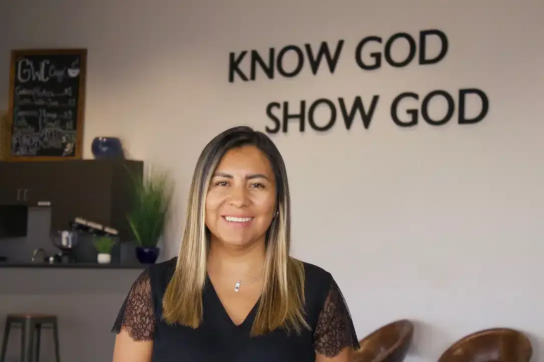 Woman smiling in front of a wall with 