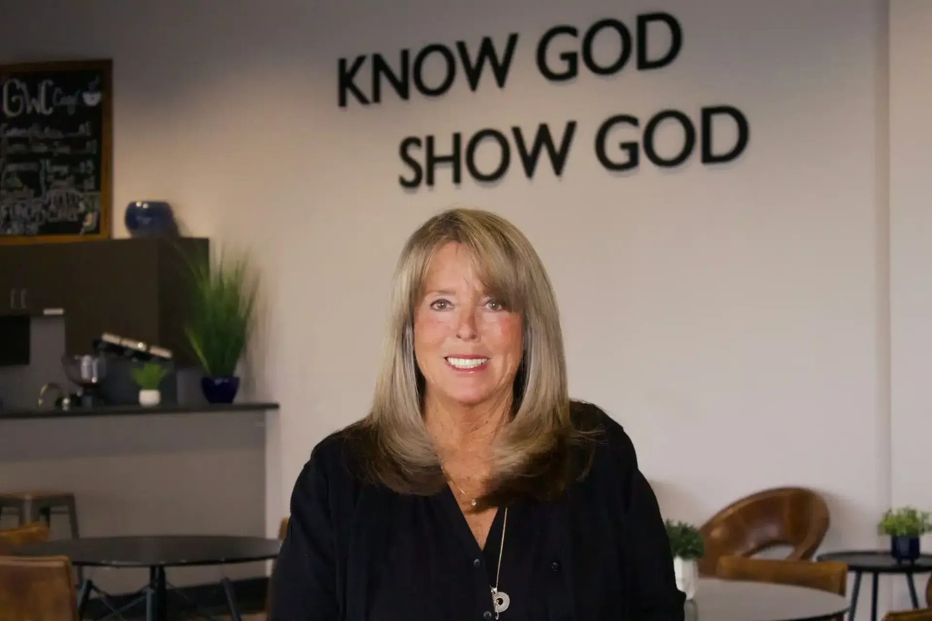 Woman smiling in front of a wall with 
