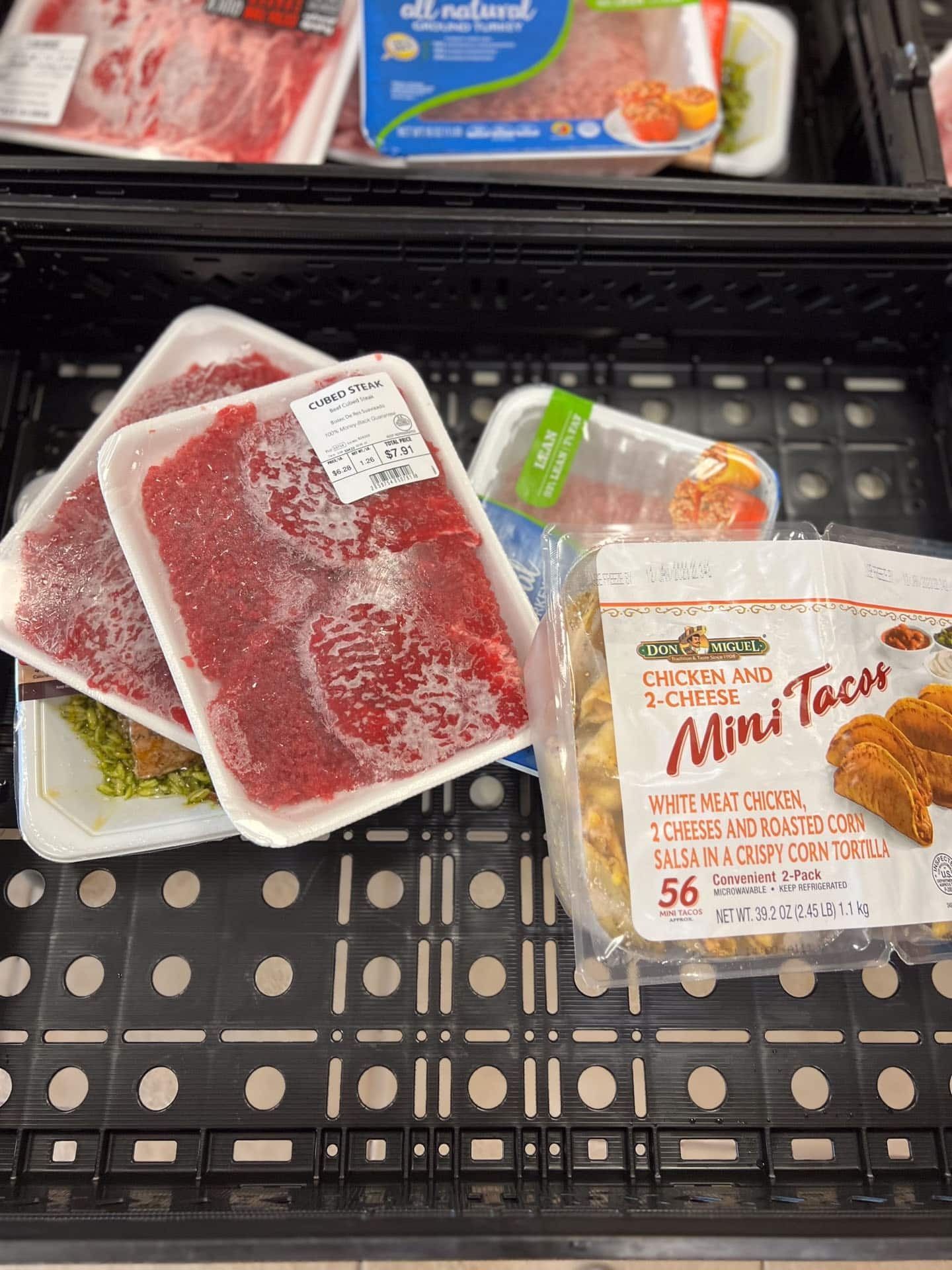 Meat and mini tacos in a black grocery basket.