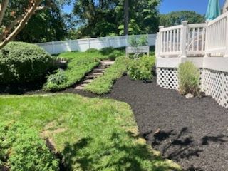 A backyard with a deck and stairs leading up to it.