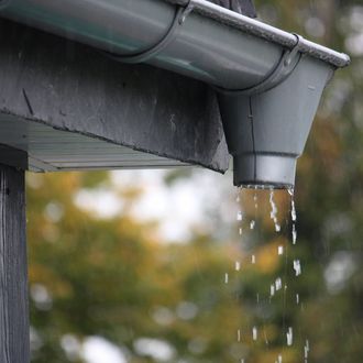 A close up of a gutter with water coming out of it