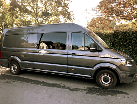 A gray van is parked on the side of the road.