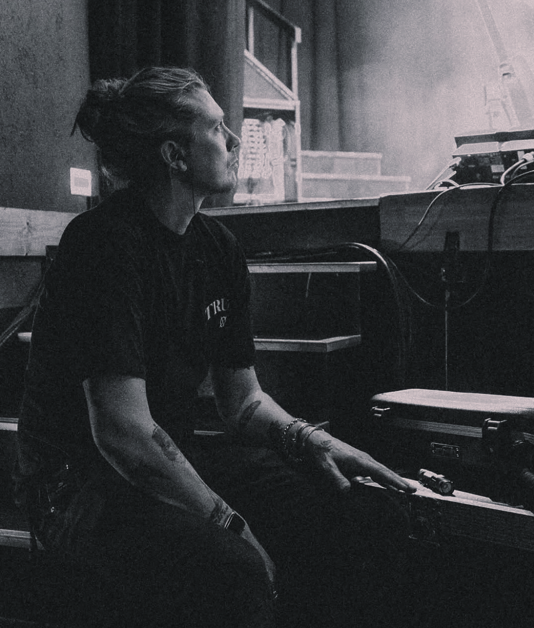 A black and white photo of a man sitting at a piano