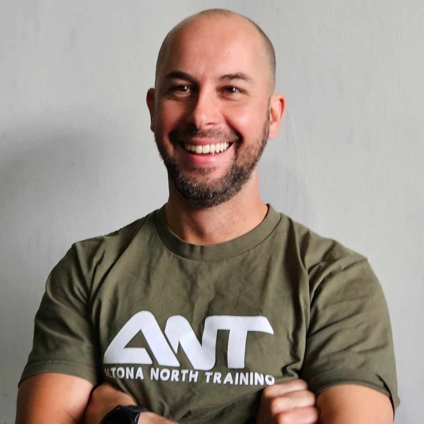 A man wearing a green shirt that says ant on it